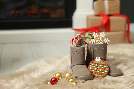 Saint Nicholas Day tradition. Child's boots with treats and ornaments in room, space for text