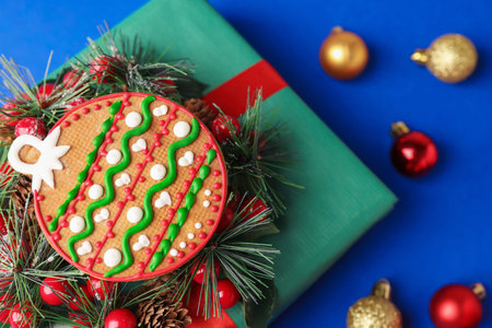 Saint Nicholas day. Gingerbread cookie, festive decor and gift box on blue background, flat lay