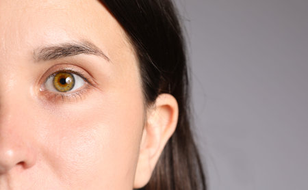 Woman with beautiful eyes on light gray background, closeup. Space for text
