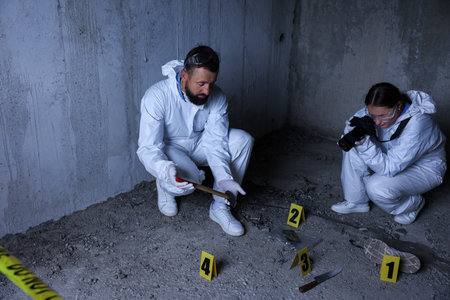 Forensic experts working at crime scene inside abandoned building