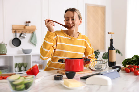 Smiling woman cooking at table in kitchenの写真素材