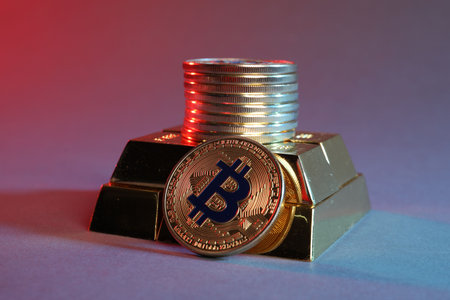 Bitcoins and gold bars on color background in red light, closeup