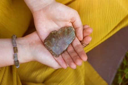 Woman meditating with crystal to heal or restore her aura outdoors, closeup