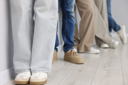 Group of people waiting in queue indoors, closeup