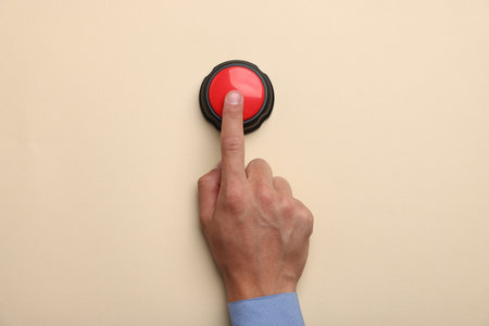 Man pressing button on beige background, top view