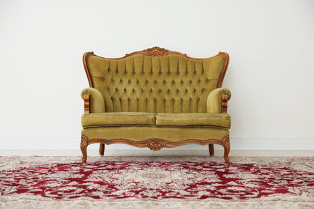 Stylish sofa near white wall in room