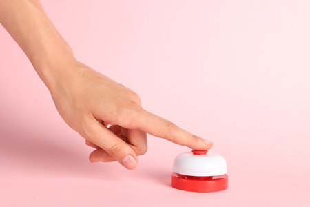 Woman pressing red button on pink background, closeup