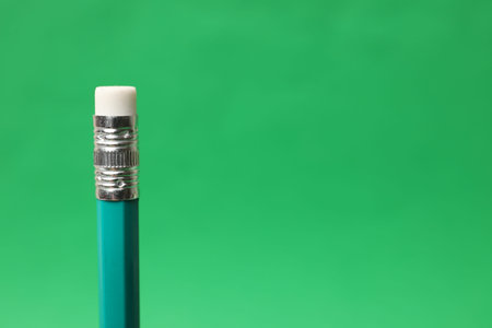 One graphite pencil on green background, closeup. Space for text