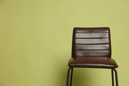 One bar stool on olive background, space for text.