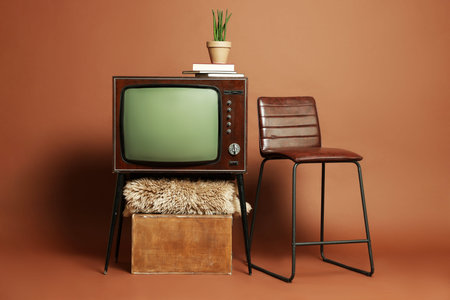 Retro TV set, stool and other stuff on brown background