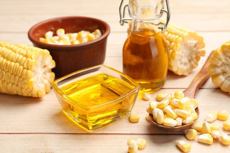 Corn butter, kernels and cobs on white wooden table, closeup