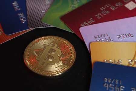 Bitcoin and plastic bank cards on black background, closeupの写真素材