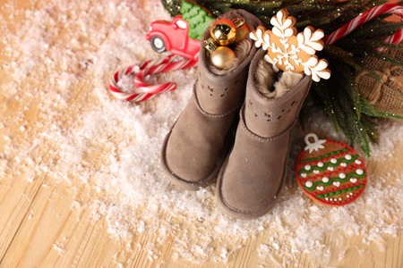 Saint Nicholas day. Boots with treats and festive decor on wooden table, above view. Space for text