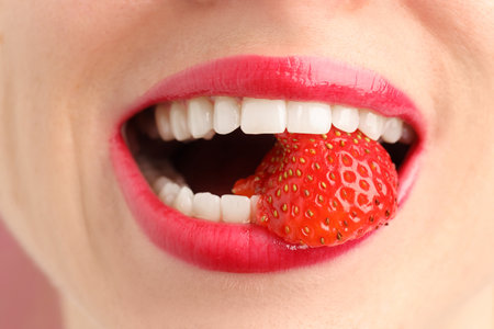 Woman with lips makeup and strawberry, closeupの写真素材