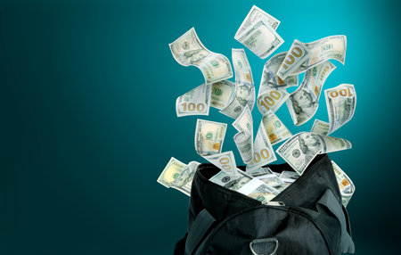 Money flying into black bag against teal gradient background. Space for textの写真素材
