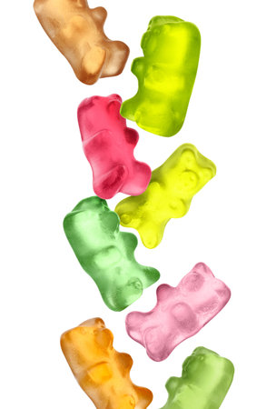 Sweet jelly candies in the shape of bear falling against white backgroundの写真素材