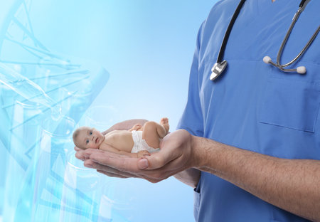 In vitro fertilization (IVF). Doctor holding little baby in hands against light blue background with test tubes and DNAの写真素材