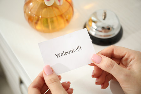 Woman holding card with the word Welcome indoors, closeupの写真素材