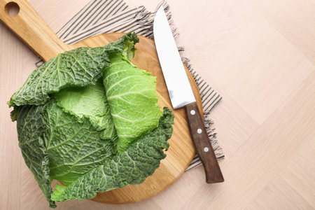 Fresh Savoy cabbage and knife on wooden table, top view. Space for textの写真素材