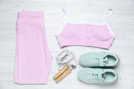 Sportswear, shoes and jumping rope on white wooden background, flat layの写真素材