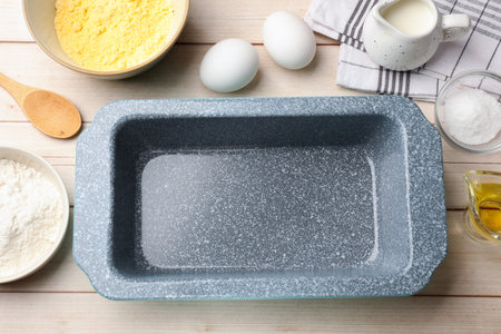 Baking dish and different ingredients for corn bread on light wooden table, flat lay. Space for textの写真素材