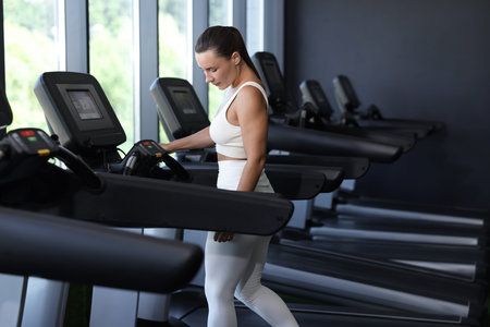 Athletic woman training on treadmill in gym