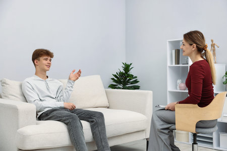 Professional psychologist working with teenage boy in officeの写真素材