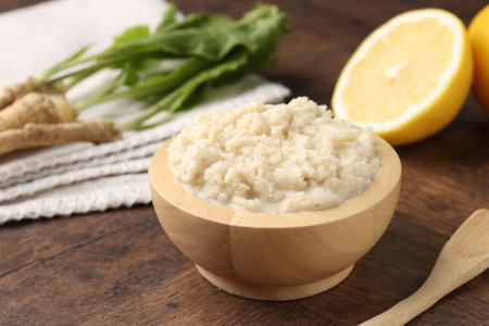 Tasty horseradish sauce and roots on wooden table, closeupの写真素材