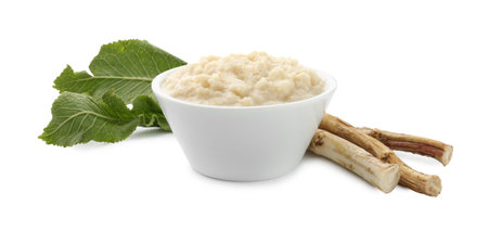 Tasty horseradish sauce in bowl, roots and leaves isolated on whiteの写真素材