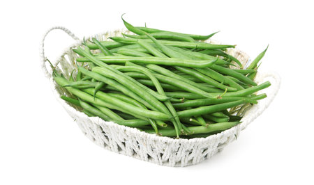 Fresh green bean pods in wicker basket isolated on white