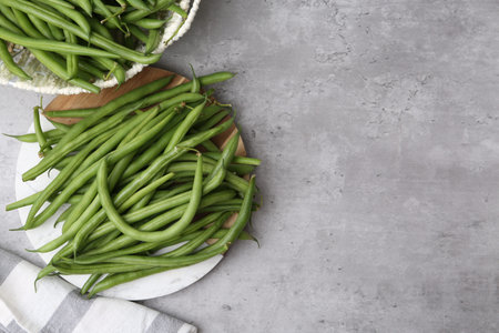 Fresh green bean pods on gray table, flat lay. Space for text