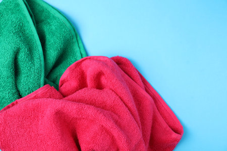 Bright terry towels on light blue background, above view. Space for textの写真素材