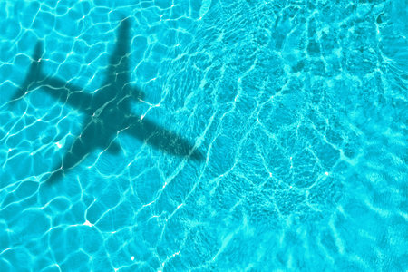 Airplane casting shadow on water, top viewの写真素材