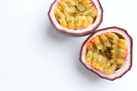 Halves of fresh passion fruit on white background, closeup. Space for text