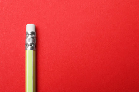 One pencil on red background, top view. Space for text