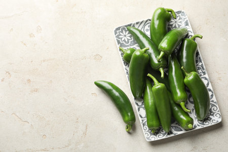 Fresh jalapeno peppers on light textured table, top view.