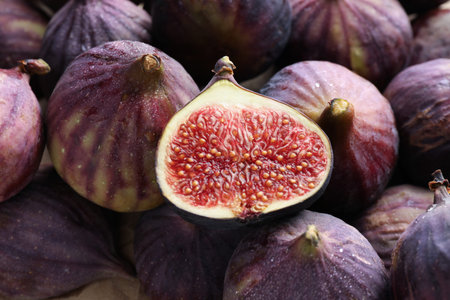 Whole and cut figs as background, top view