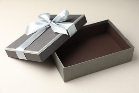 Open gift box with beautiful lid on light gray background