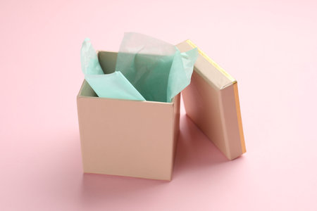 Open gift box with lid on pink background