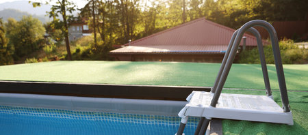 Outdoor swimming pool with clean water and ladder at resort