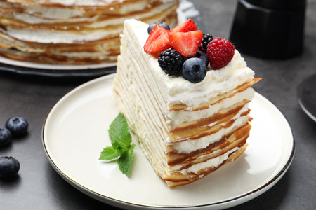Piece of tasty crepe cake with berries on gray table, closeupの写真素材