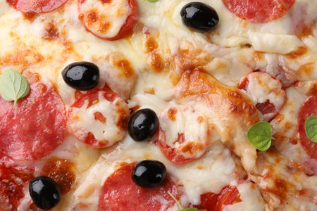 Delicious pizza with cheese, salami and olives as background, top viewの写真素材