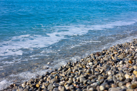 Beautiful view of wavy sea and pebbles on beach