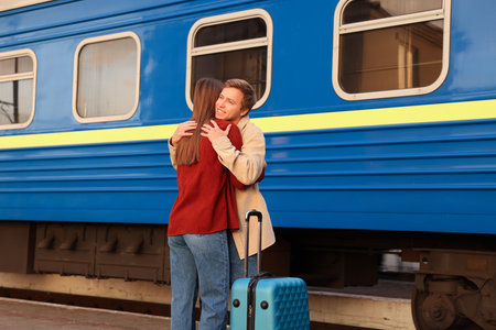 Goodbye. Lovely couple hugging on platform of railway stationの写真素材