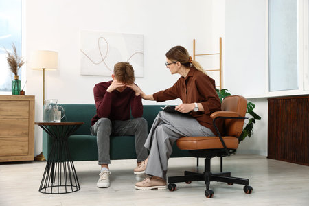 Professional psychologist working with teenage boy in office