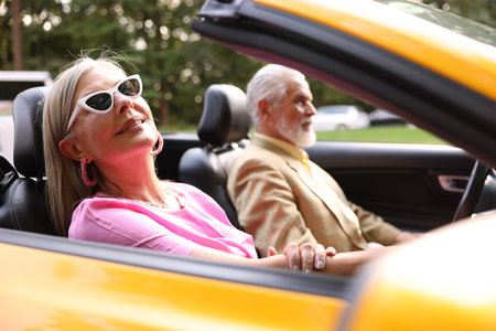 Senior couple enjoying cabriolet ride in city, selective focusの写真素材