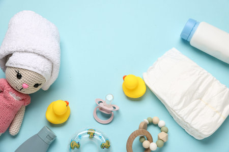 Baby bath accessories, cosmetic products and toys on light blue background, flat lay