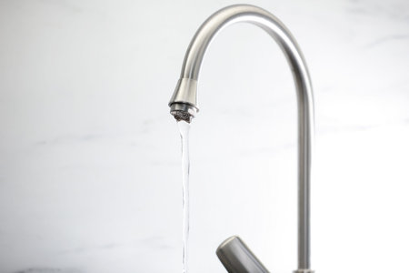 Save water concept. Stream of water flowing from tap against light background, closeupの写真素材