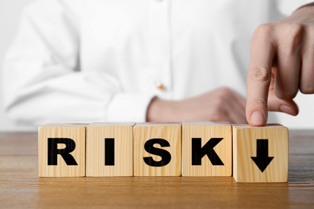 Business risk. Woman touching wooden cube with arrow at table, closeup