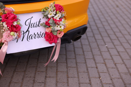 Wedding car. Cabriolet decorated with Just Married card and beautiful flowers outdoors, closeupの写真素材